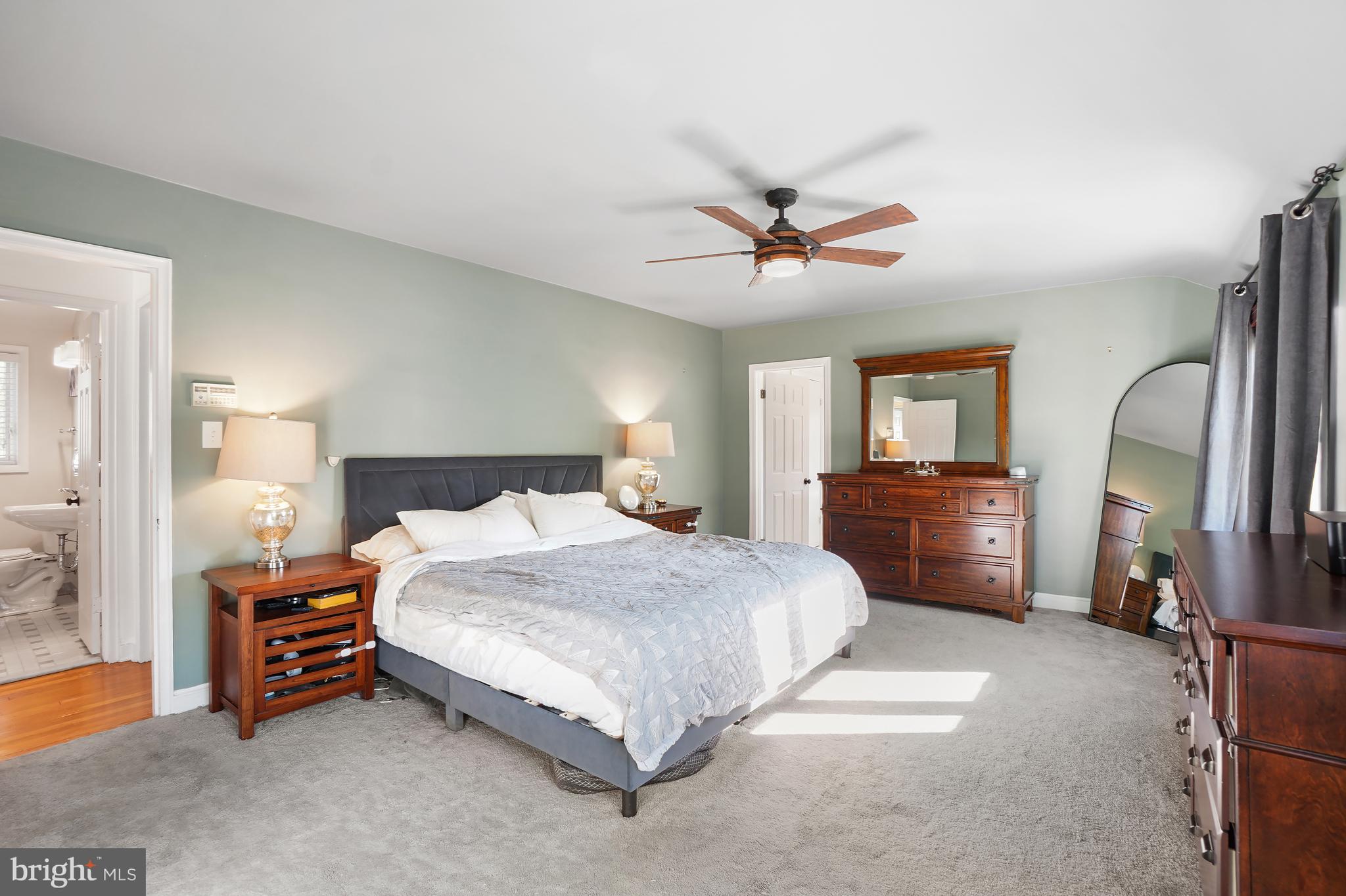 1303 Ballard Street Silver Spring, MD 20910 - Photo 30 of 53 a spacious bedroom with a bed a dresser and a chandelier