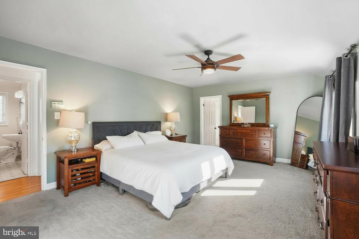 1303 Ballard Street Silver Spring, MD 20910 - Photo 33 of 53 a spacious bedroom with a bed a dresser and a chandelier