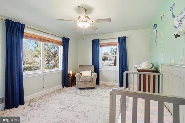 a view of an empty room with window and chandelier fan