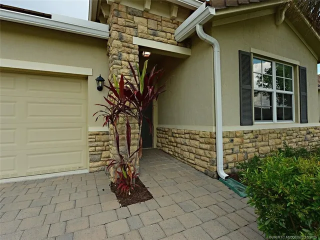 a large kitchen with stainless steel appliances granite countertop a stove top oven a sink dishwasher and a refrigerator with wooden floor