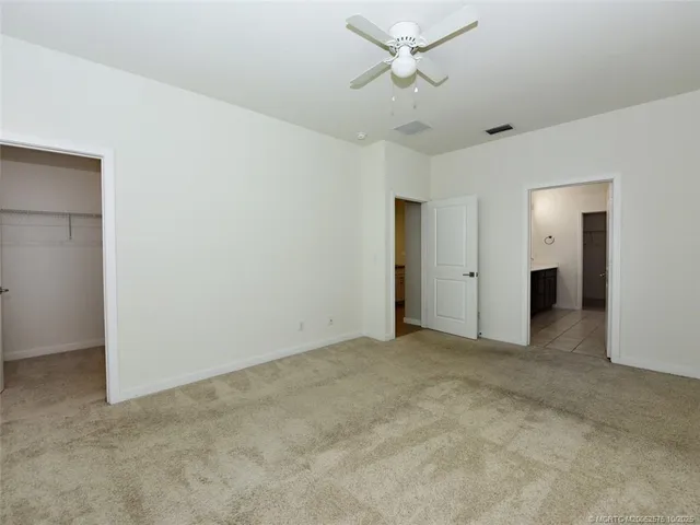 an empty room with a window and a ceiling fan