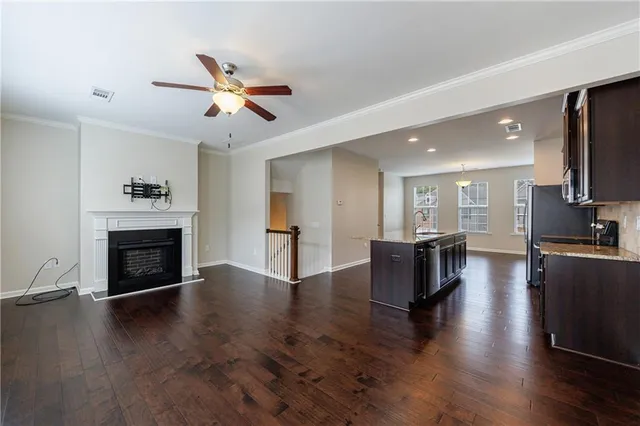 a view of a livingroom with fireplace wooden floor and a ceiling fan