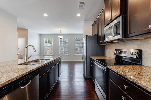 a kitchen with stainless steel appliances granite countertop counter space a stove and cabinets