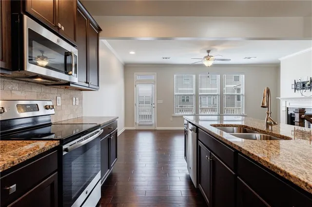 a kitchen with stainless steel appliances granite countertop a sink a stove and a microwave