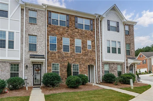a front view of a house with yard and green space