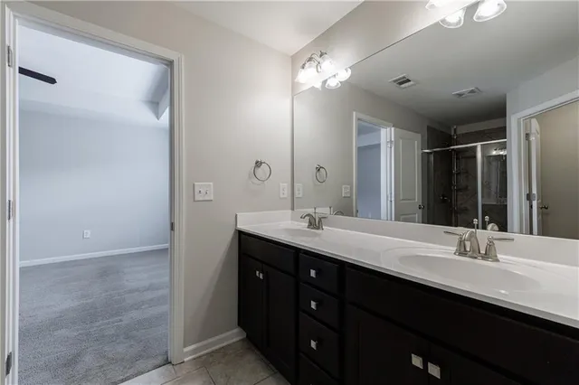 a bathroom with a double vanity sink a mirror and a shower