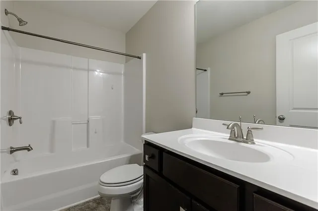 a bathroom with a sink a toilet and a large mirror