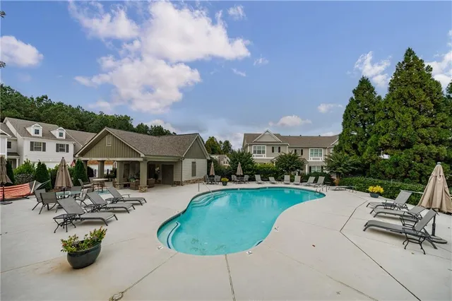 a view of a sign board with flower plants and wooden fence