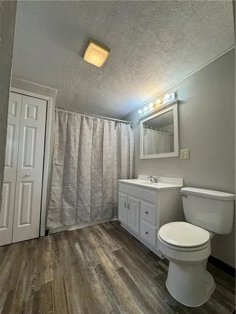 a bathroom with a granite countertop toilet sink and mirror