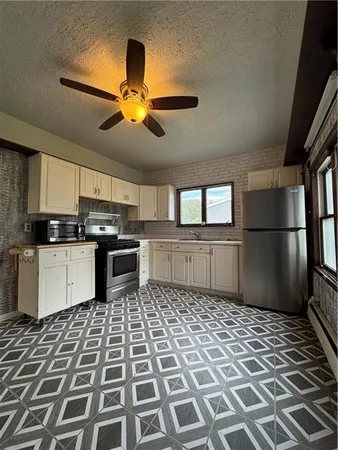 a kitchen with stainless steel appliances granite countertop a refrigerator a stove a sink and dishwasher