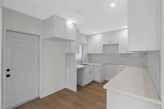 a kitchen with a sink cabinets and wooden floor