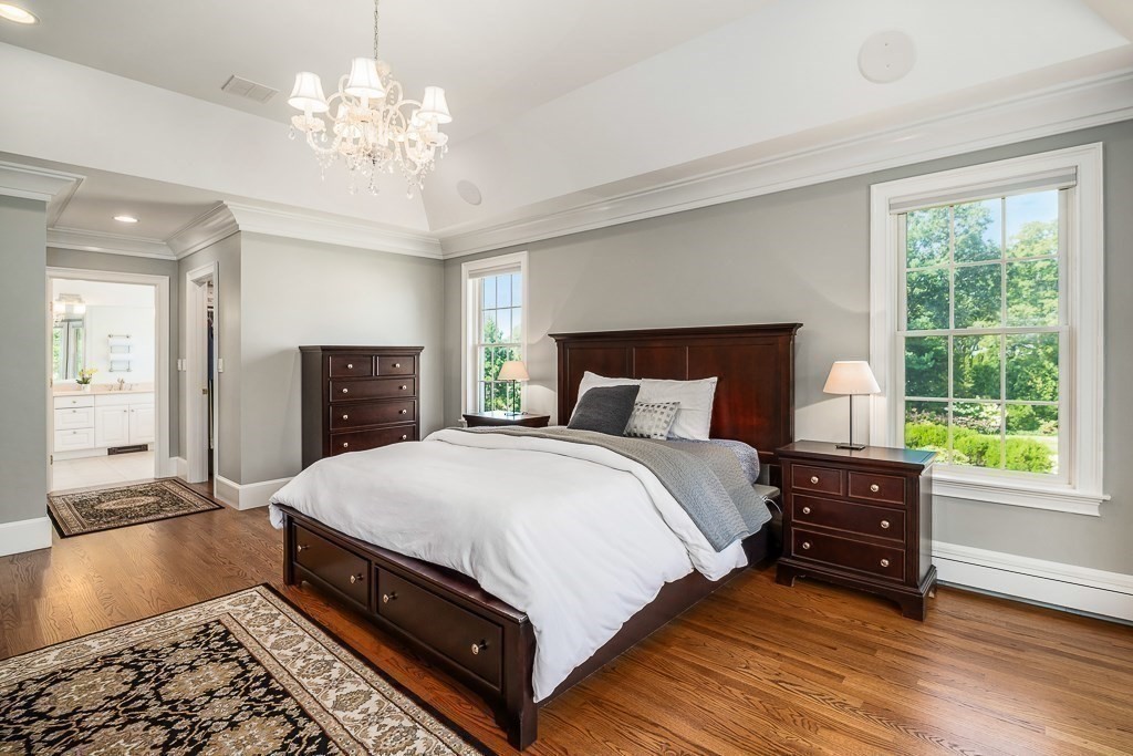 17 Patton Drive Hamilton, MA 01982 - Photo 23 of 37 a bedroom with a bed and a chandelier