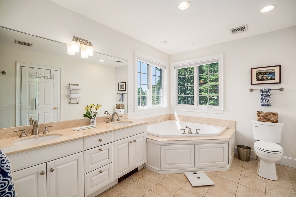 17 Patton Drive Hamilton, MA 01982 - Photo 24 of 37 a spacious bathroom with a double vanity sink a large mirror and a bathtub
