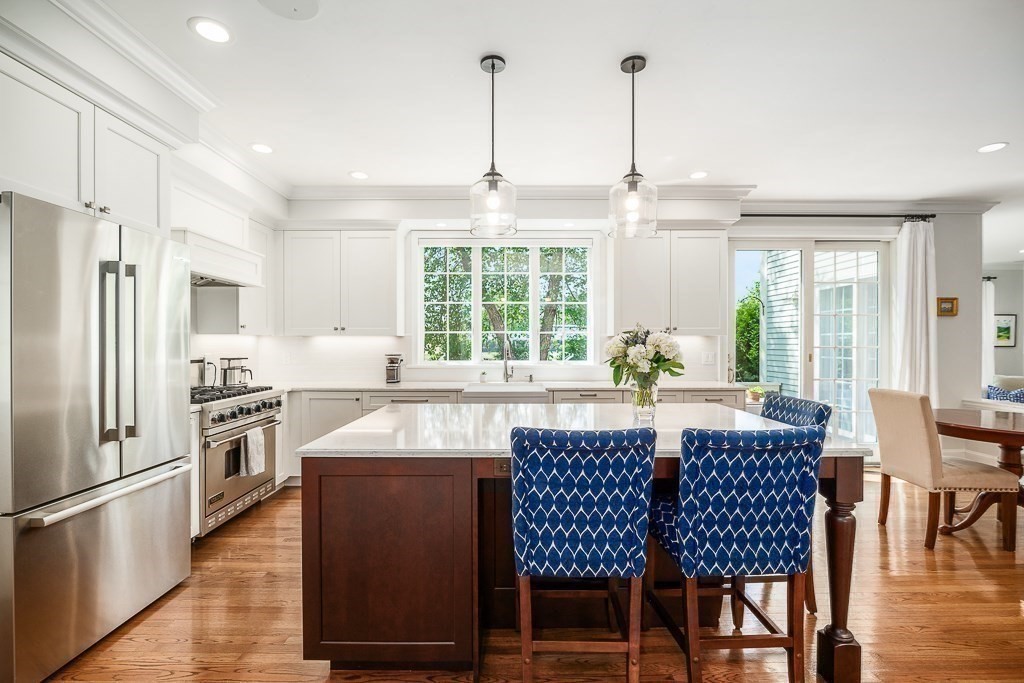 17 Patton Drive Hamilton, MA 01982 - Photo 10 of 37 a kitchen with stainless steel appliances granite countertop a stove a refrigerator a kitchen island a table and chairs