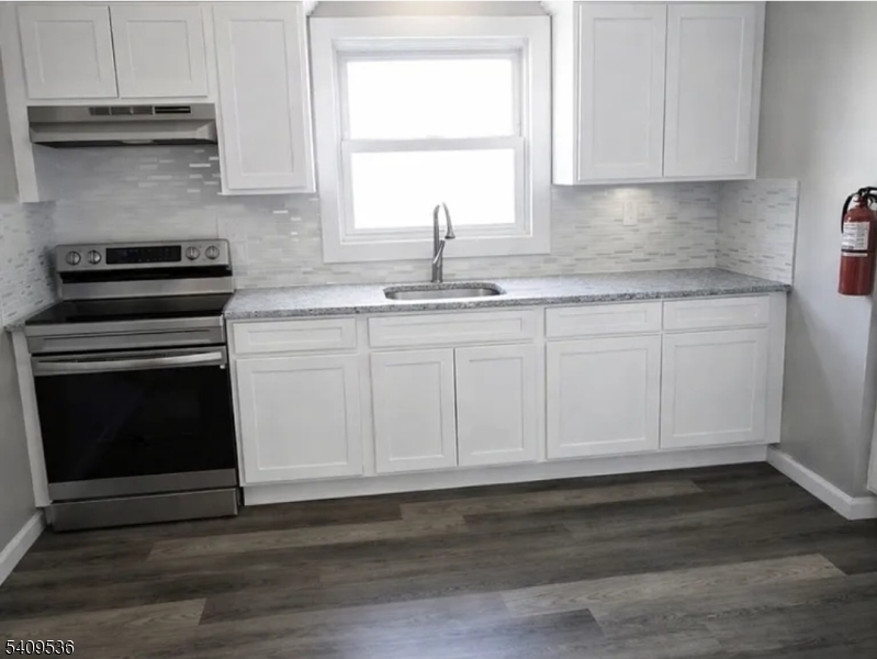 1066 Mary Street Elizabeth, NJ 07201 - Photo 2 of 6 a kitchen with granite countertop white cabinets and a stove