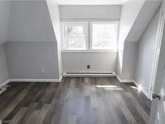 an empty room with wooden floor and window