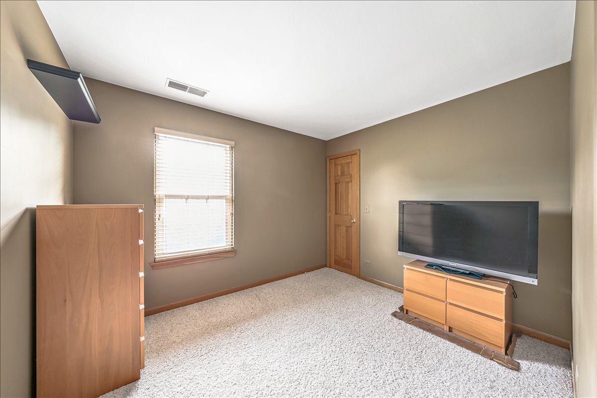 3 Taylor Court, Unit B Streamwood, IL 60107 - Photo 18 of 30 a living room with a flat screen tv and a dresser