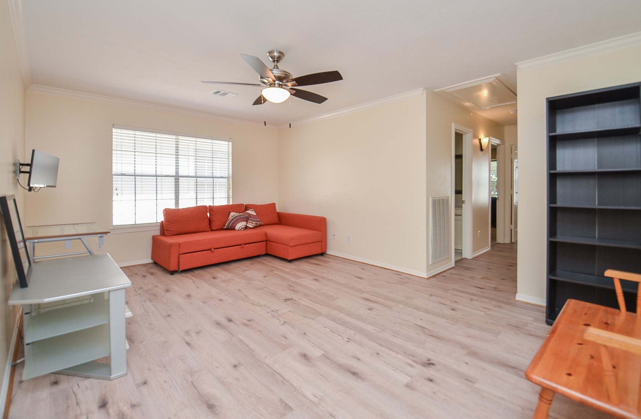 4916 Inker Street Houston, TX 77007 - Photo 21 of 36 Natural light, ceiling fan and ample space in this gameroom, which splits the primary bedroom from the secondary rooms. Let's head down this hall to the secondary rooms.
