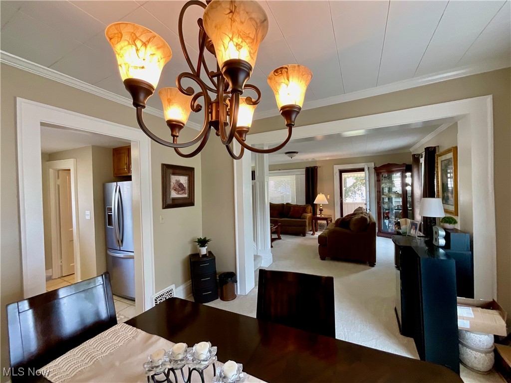 904 Chalker Street Akron, OH 44310 - Photo 4 of 28 Dining space with a chandelier, ornamental molding, and light colored carpet