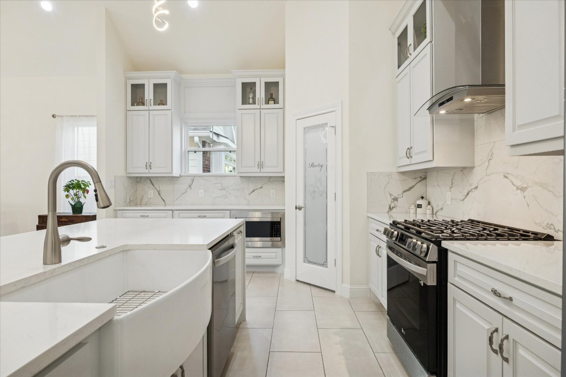 532 Carrell Street Tomball, TX 77375 - Photo 12 of 28 The elegant kitchen features a highly sought-after farmhouse sink, quartz countertops throughout the island, including the sides, adding both sophistication and functionality. Durable and low-maintenance quartz surfaces provide excellent resistance to spills, making this kitchen ideal for today’s families.