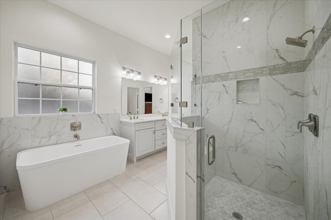 532 Carrell Street Tomball, TX 77375 - Photo 16 of 28 A closer view of the shower showcases its generous size, frameless glass enclosure, marble wall finishes, and refined accents, creating a sophisticated, spa-like setting that is simply beautiful.