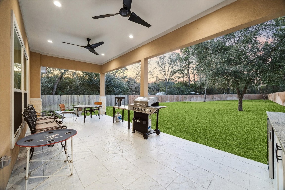 532 Carrell Street Tomball, TX 77375 - Photo 22 of 28 Amazing covered patio, perfect for gatherings or relaxing with loved ones while enjoying beautiful views of the spacious backyard. This outdoor space also features an outdoor kitchen, energy-efficient LED lighting, and ceiling fans, ideal for summer enjoyment.