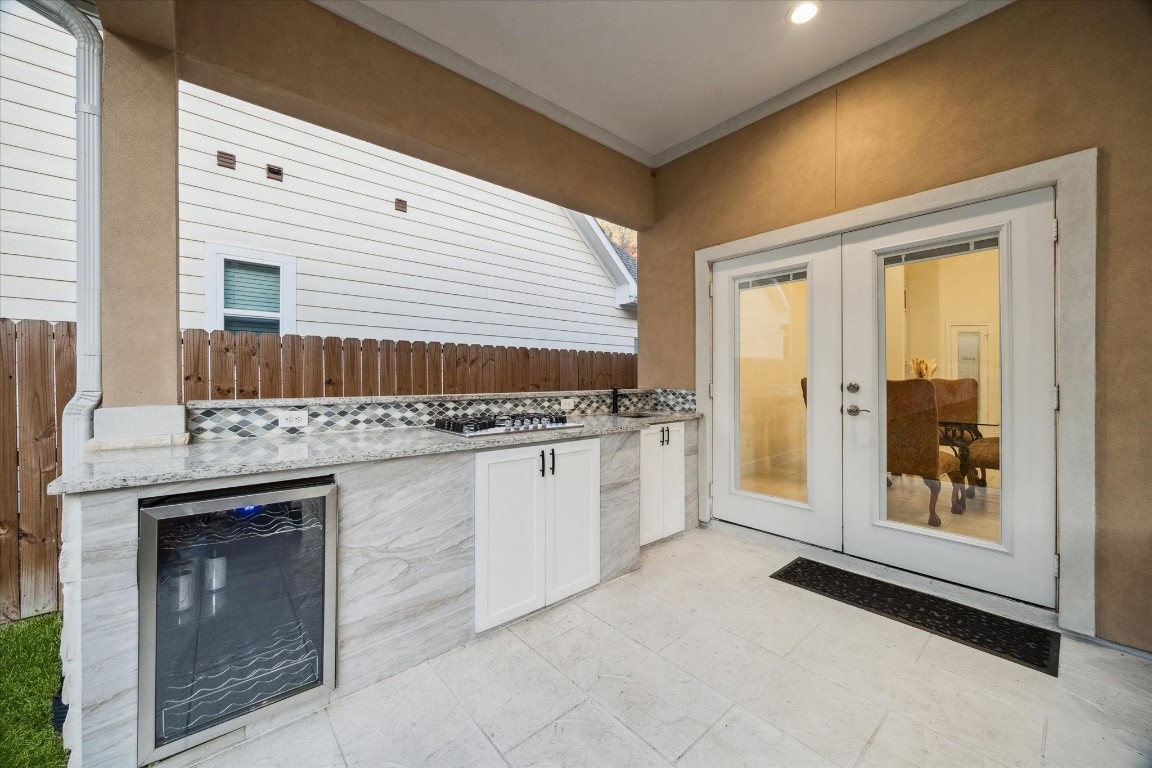 532 Carrell Street Tomball, TX 77375 - Photo 23 of 28 This closer view highlights the outdoor kitchen, equipped with a gas cooktop, granite countertops, and a sink. Designed for both convenience and entertainment, it offers a perfect setting for gatherings and outdoor enjoyment.