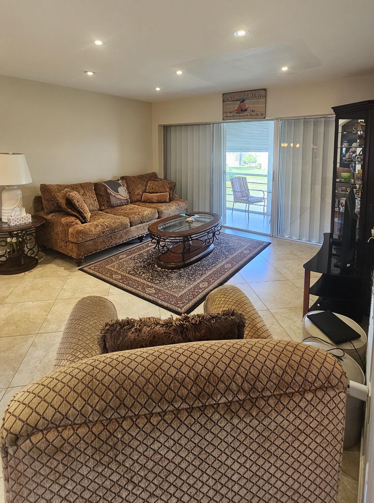 504 Davis Road, Unit 96 Palm Springs, FL 33461 - Photo 12 of 42 a living room with a couch and a flat screen tv