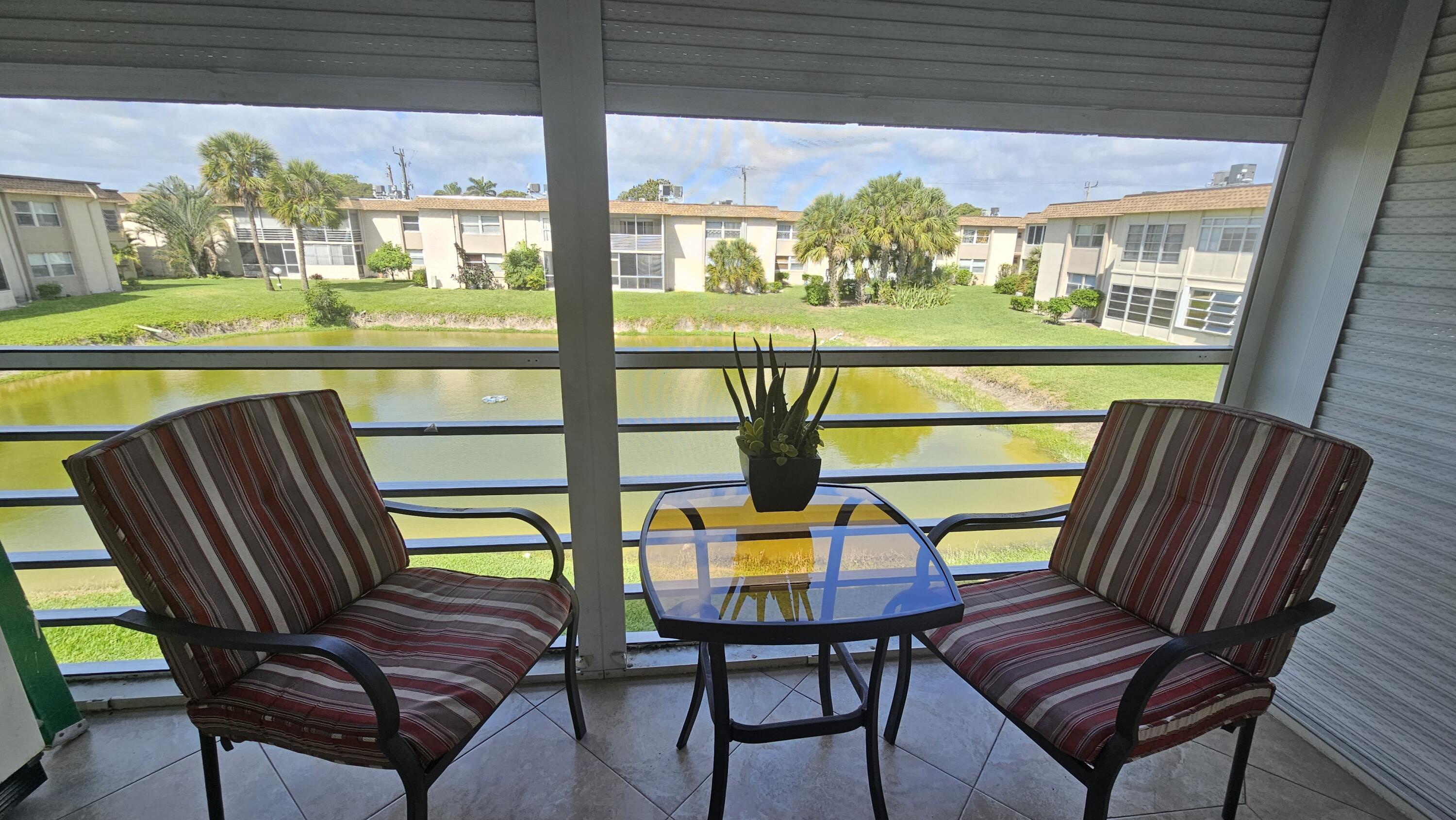 504 Davis Road, Unit 96 Palm Springs, FL 33461 - Photo 13 of 42 a view of a chairs and table in patio with a yard