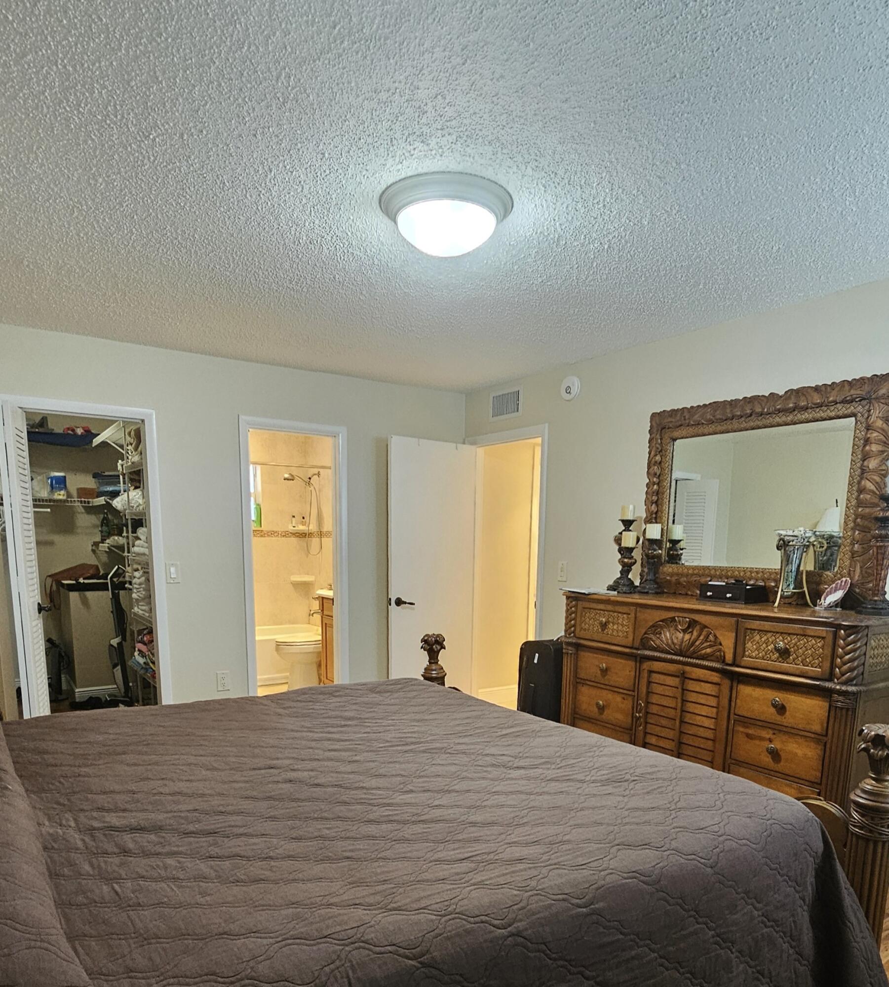 504 Davis Road, Unit 96 Palm Springs, FL 33461 - Photo 22 of 42 a bedroom with a bed and a dresser