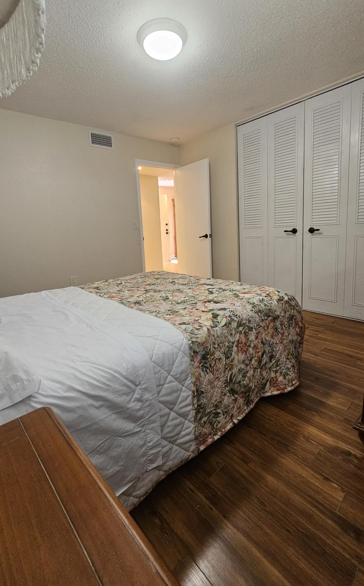 504 Davis Road, Unit 96 Palm Springs, FL 33461 - Photo 26 of 42 a bedroom with a bed and wooden floor