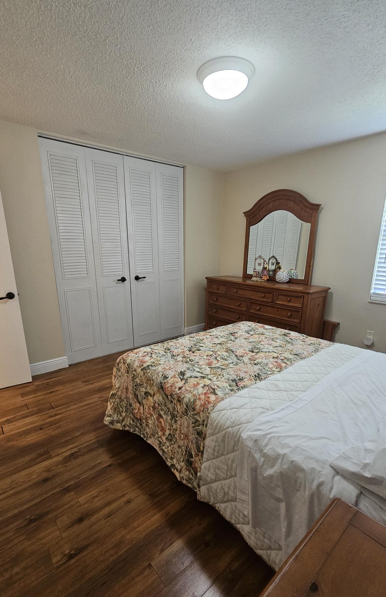 504 Davis Road, Unit 96 Palm Springs, FL 33461 - Photo 27 of 42 a bedroom with a bed and wooden floor