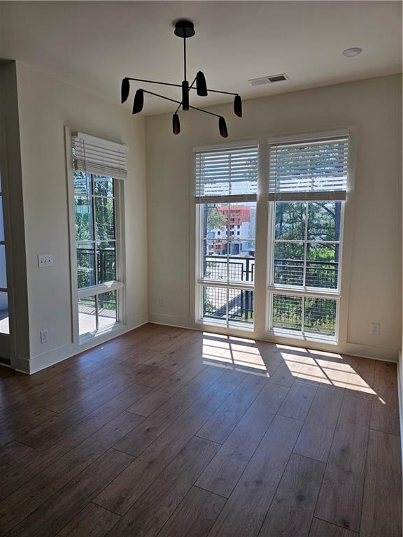 1294 Longreen Terrace Northwest, Unit 2 Atlanta, GA 30318 - Photo 5 of 25 a view of an empty room with wooden floor and a window