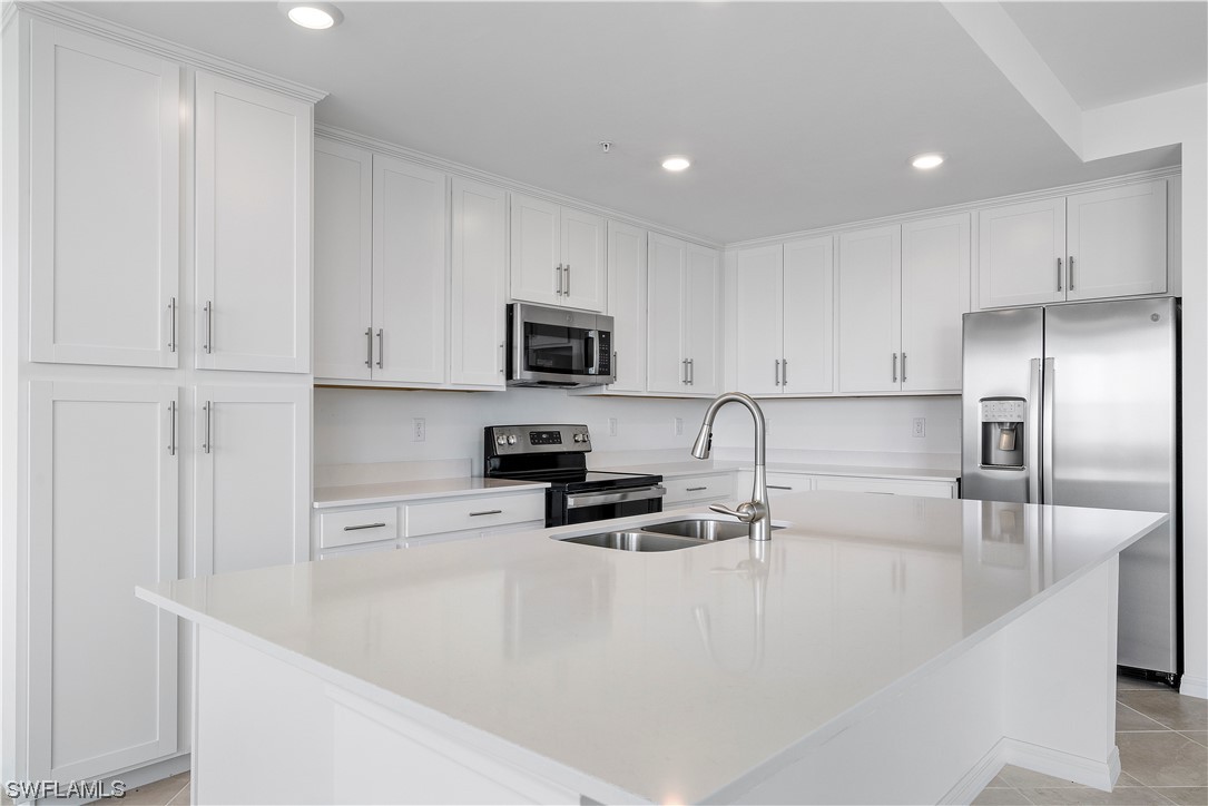 43989 Boardwalk Loop, Unit 2033 Punta Gorda, FL 33982 - Photo 24 of 36 a kitchen with granite countertop a refrigerator sink and white cabinets