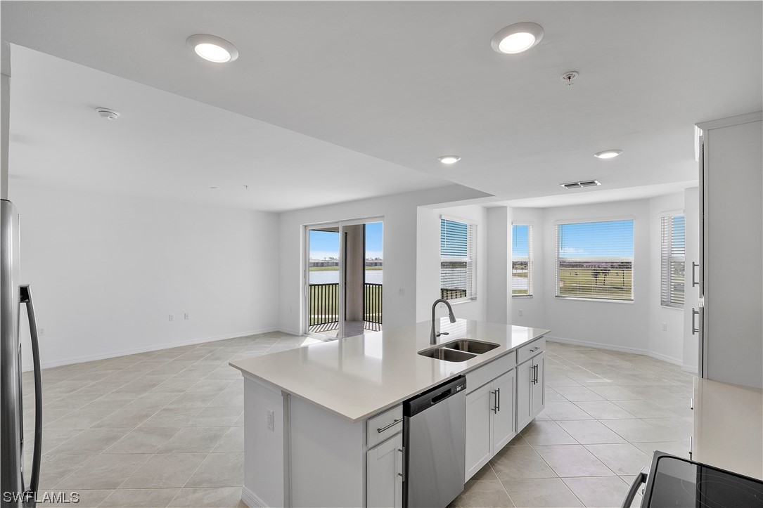 43989 Boardwalk Loop, Unit 2033 Punta Gorda, FL 33982 - Photo 25 of 36 a kitchen with granite countertop a sink and white cabinets