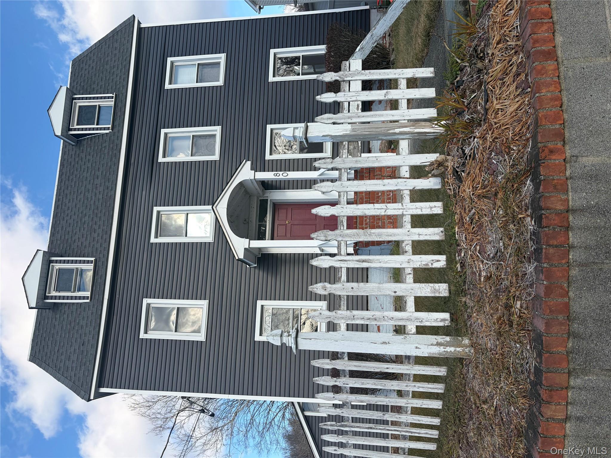 View of front of house featuring a fenced front yard and roof with shingles