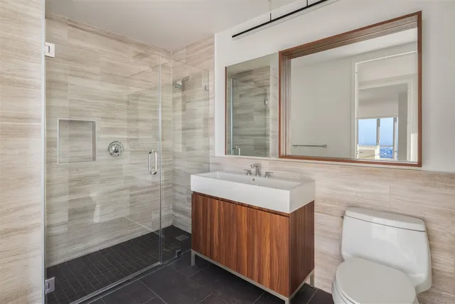 a bathroom with a toilet sink vanity and mirror
