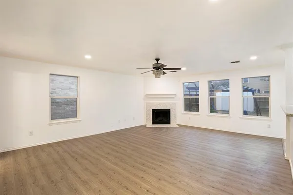 a view of empty room with wooden floor and fireplace