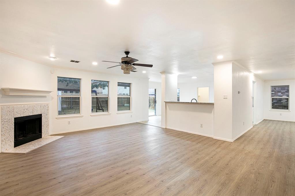 4800 Sleepy Ridge Circle Fort Worth, TX 76133 - Photo 7 of 40 a view of an empty room with wooden floor and a kitchen
