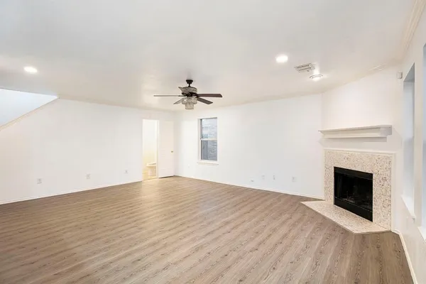 a view of empty room with wooden floor and fireplace