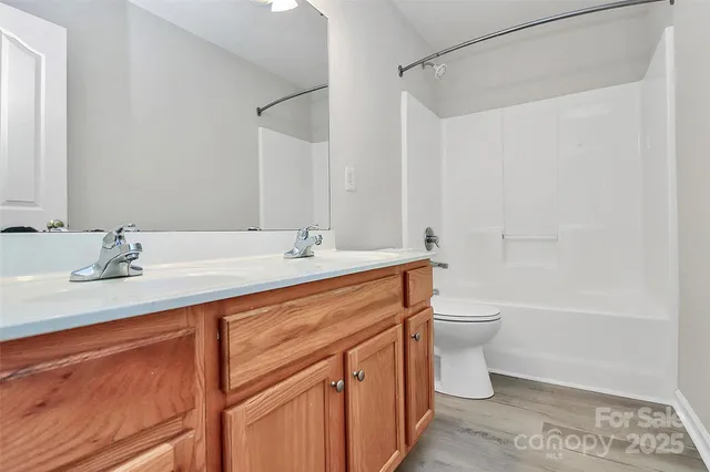 a bathroom with a double vanity sink toilet and shower