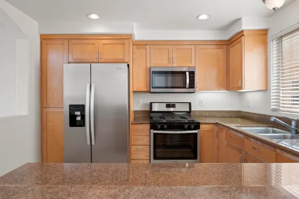 a kitchen with stainless steel appliances granite countertop a refrigerator stove and microwave