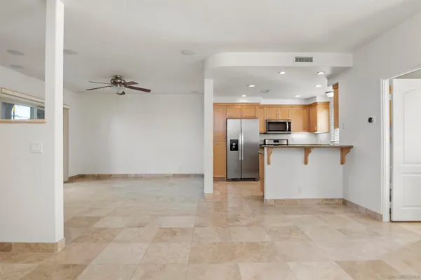a view of kitchen with refrigerator and white cabinets