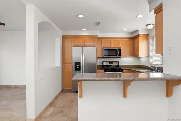 a kitchen with stainless steel appliances granite countertop a refrigerator and a stove