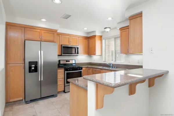a kitchen with stainless steel appliances granite countertop a sink a stove and a refrigerator