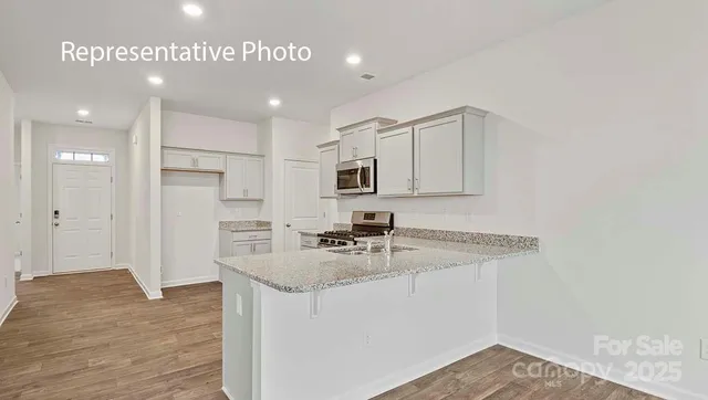 a kitchen with kitchen island a sink stainless steel appliances and cabinets