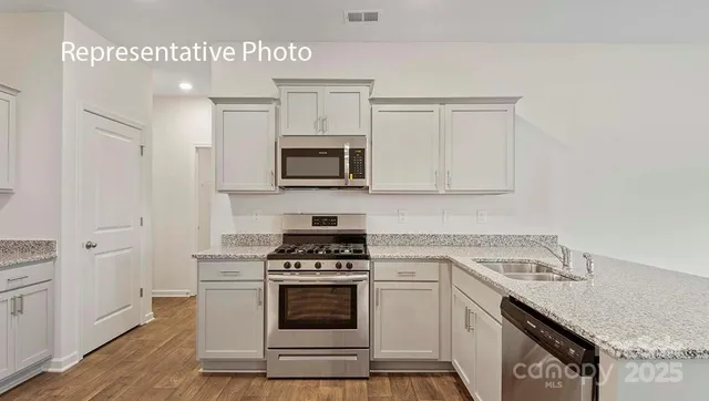 a kitchen with sink a microwave and cabinets