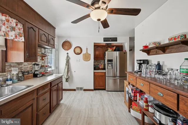 a kitchen with stainless steel appliances granite countertop a refrigerator a stove a sink and dishwasher with wooden floor