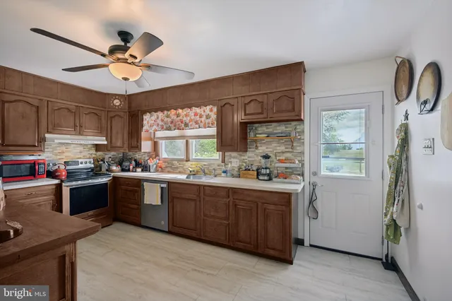 a kitchen with cabinets a window and appliances