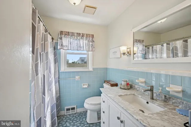a bathroom with a granite countertop toilet sink and mirror